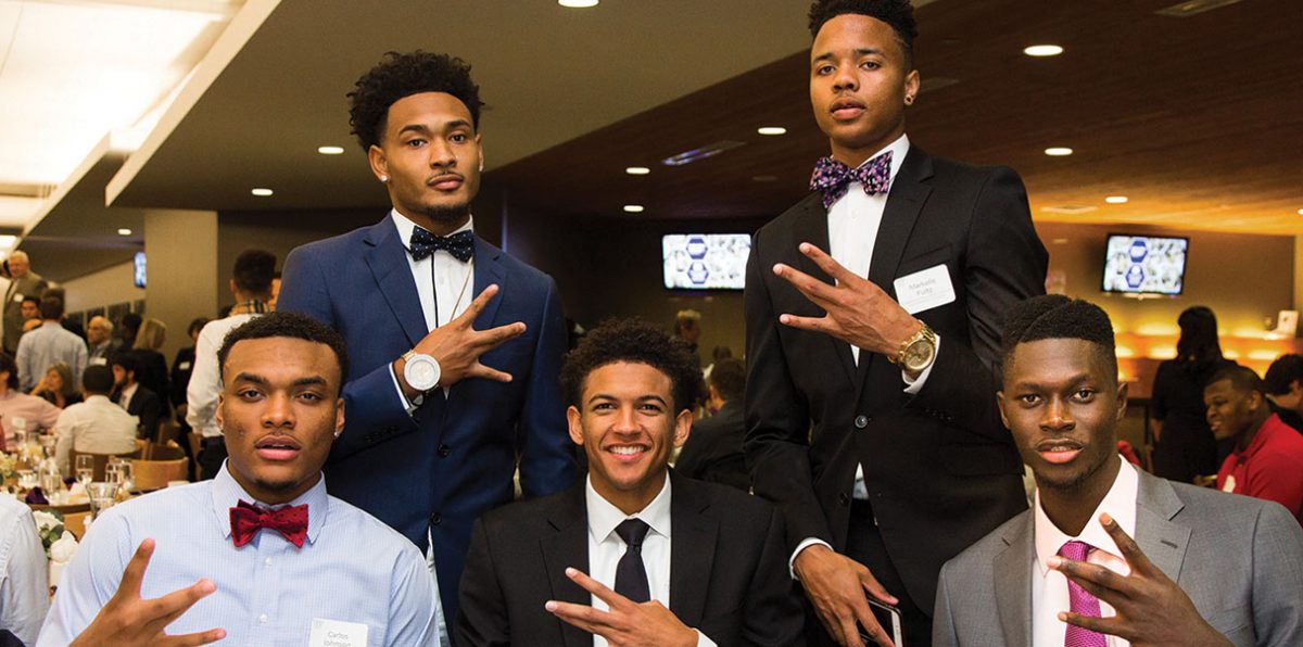 Men's Basketball student-athletes pose with Dubs up at annual donor appreciation scholarship dinner.