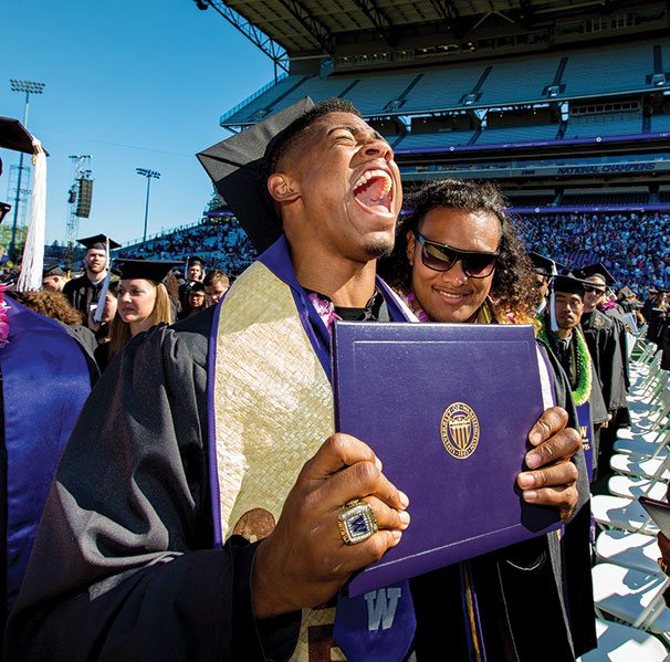 UW student-athlete holds diploma and screams with joy.