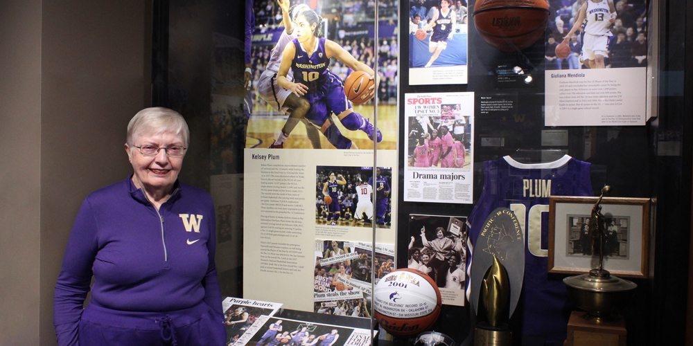 Karen Koon in front of the Kelsey Plum display in the Husky Hall of Fame