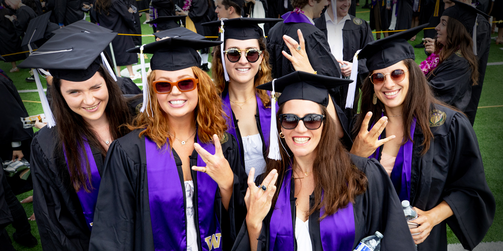 UW student-athletes pose with Dubs Up at graduation