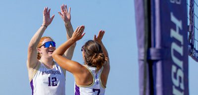 Chloe Loreen high fives a fellow Beach Volleyball teammate after a great play