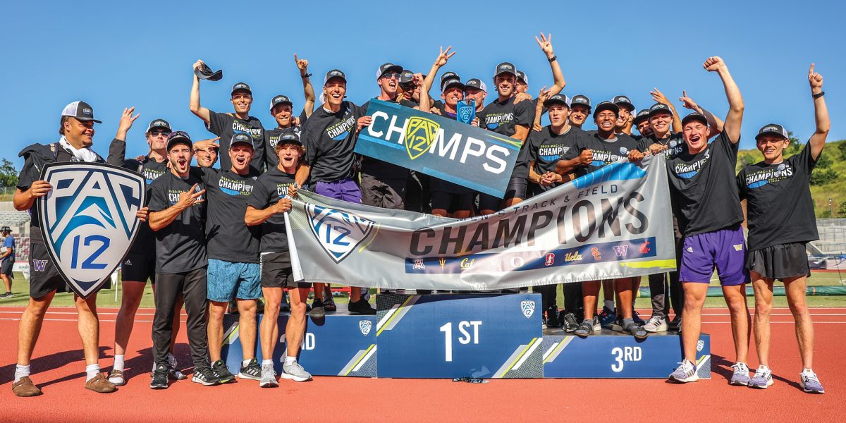 Men's Track and Field team stands on podium holding Pac-12 Championship banner