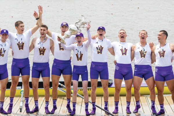 Men's Rowing cheering and holding IRA Championship trophy