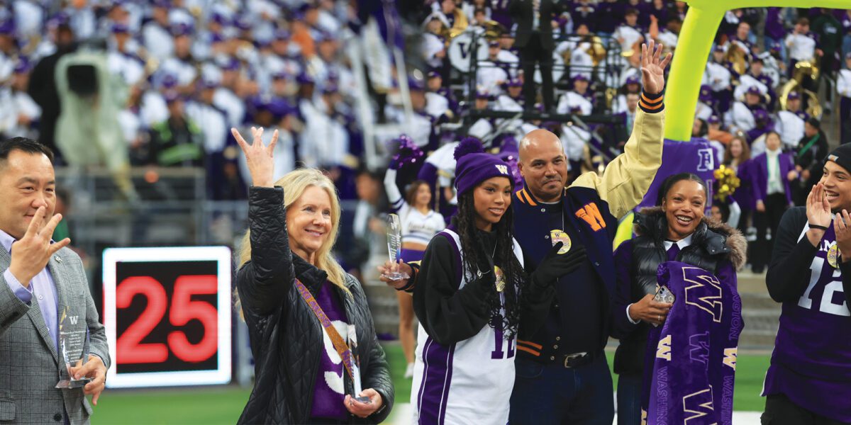 Kerry Sawyer Odeman and Jason Hamilton receive awards during a Husky Football game