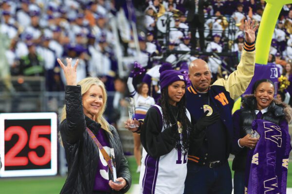 Kerry Sawyer Odeman and Jason Hamilton receive awards during a Husky Football game