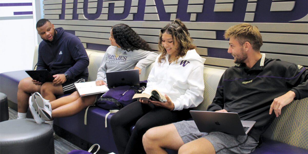 Four student-athletes studying in Ackerley Academic center