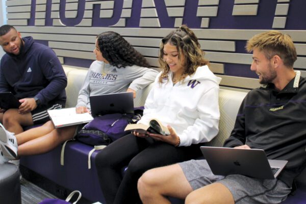 Four student-athletes studying in Ackerley Academic center