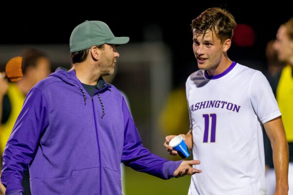 Coach Clark talks to Scott Menzies during soccer match
