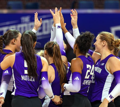 Volleyball team with Dubs Up held high over huddle