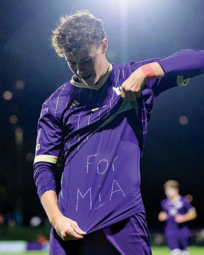 Men's Soccer player, Nick O'Brien lifts jersey to reveal purple shirt inscribed with "For Mia"
