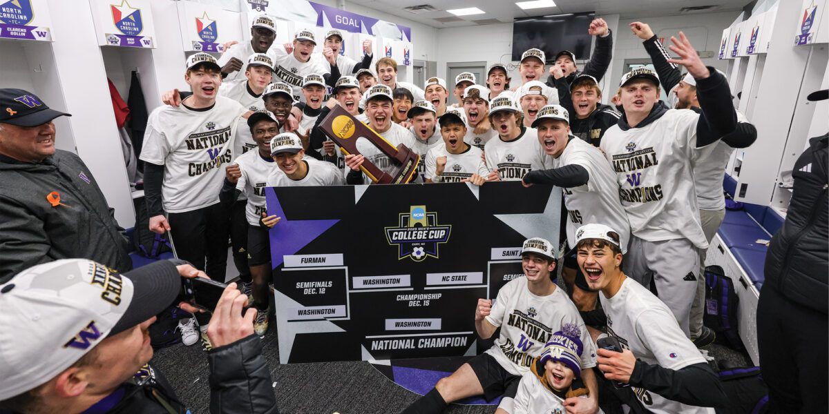 Men's Soccer team poses with National Championship trophy in locker room