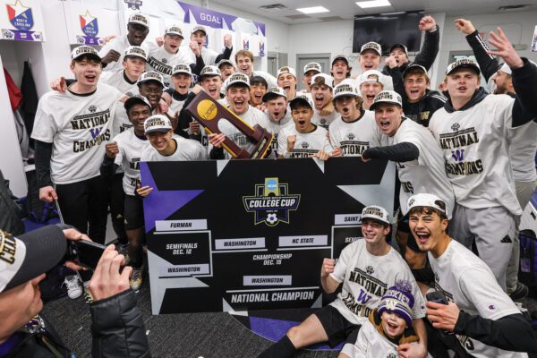 Men's Soccer team poses with National Championship trophy in locker room